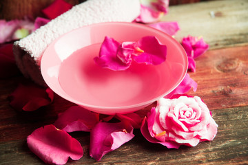 Spa setting with rose pink flowers and petals,bath salt and body-oil