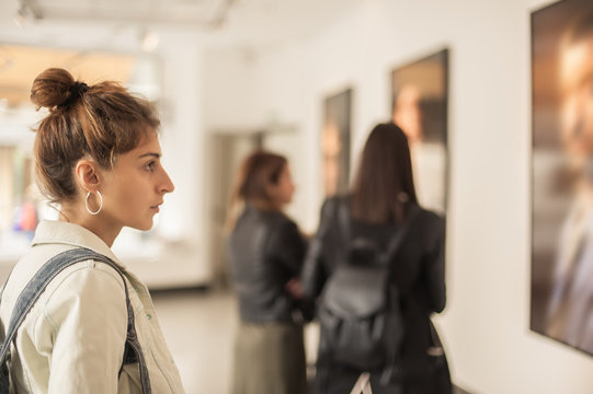 Group of woman looking at modern painting in art gallery