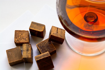 Cognac with dark chocolate on white background