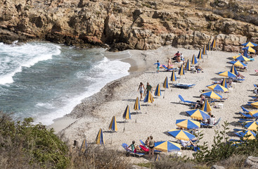 Beach and sunshades on the Cretan seaside resort of Sisi close to Malia, Crete, Greece. October 2017