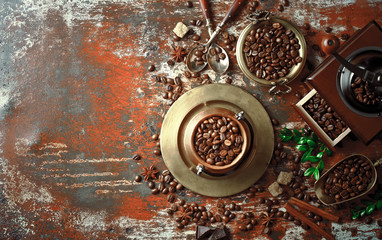 Black coffee in a cup on the table in a composition with coffee accessories on an old background