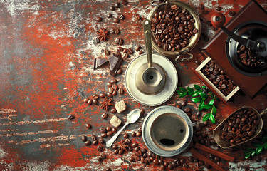 Black coffee in a cup on the table in a composition with coffee accessories on an old background