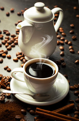 Black coffee in a cup on the table in a composition with coffee accessories on an old background