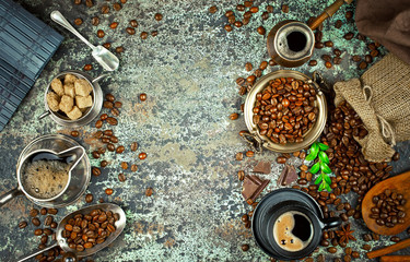 Black coffee in a cup on the background of coffee beans in a composition with accessories