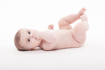 Plakat naked baby lies on his back and looks at the camera