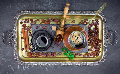 Black coffee in a cup on the background of coffee beans in a composition with accessories