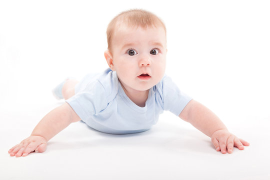 baby in the body lying on his stomach on a white background and looking at the camera