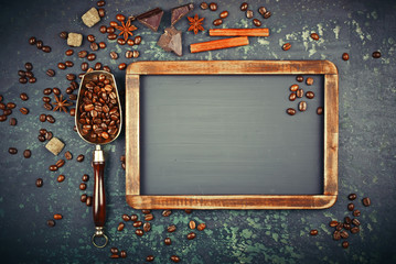 Black coffee in a cup on the table in a composition with coffee accessories on an old background