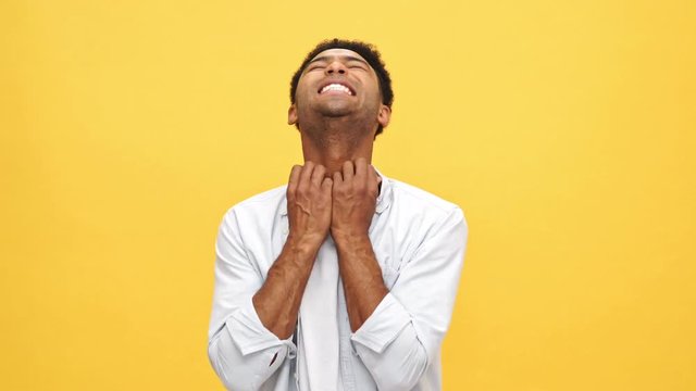 Young african man in shirt having itch over yellow background