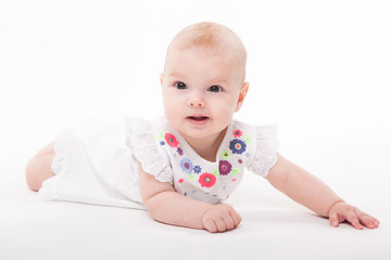 Baby girl on a white background in a smart dress