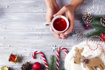 Woman holding in hands hot christmas tea with candy