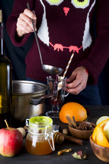 female hands pouring hot mulled wine