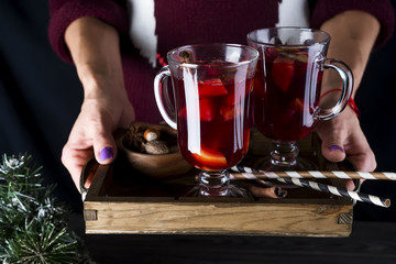 in female hands tray with hot mulled wine
