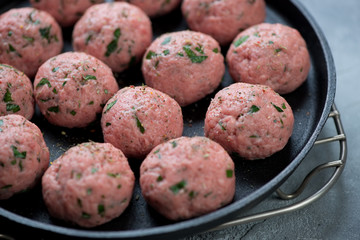 Closeup of raw meatballs made of beef meat with addition of ricotta cheese and parsley