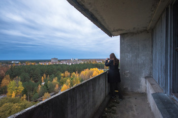 Girl taking photo in Pripyat Chernobyl Zone, autumn time Chernobyl, Ukraine