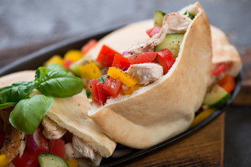 Pita sandwiches with grilled chicken meat and vegetables, shallow depth of field, close-up