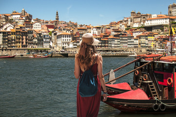 Yougn woman in red dress traveling in Portugal - obrazy, fototapety, plakaty