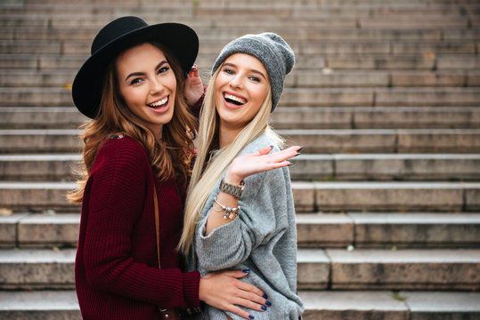 Portrait of two cheerful attractive girls hugging