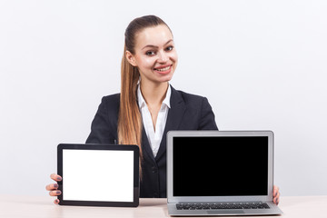 Picture of beautiful business lady showing PC and tablet computer