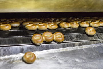 Many ready-made fresh bagels in a bakery oven in a bakery. Bread making business. Soft focus