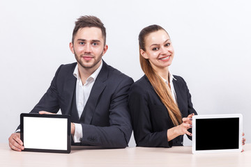 Picture of couple of office workers both holding tablet