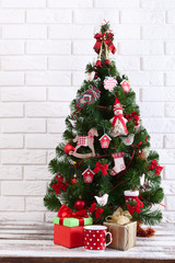 White wooden table in front of colorful christmas tree with gift boxes. Can be used for display or montage your products