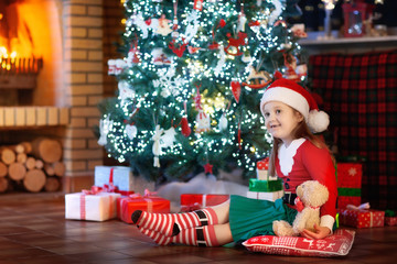 Child at Christmas tree. Kid at fireplace on Xmas