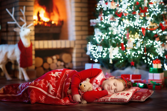 Child at Christmas tree. Kid at fireplace on Xmas