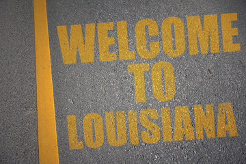 asphalt road with text welcome to louisiana near yellow line.