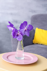 Vase with lilac flowers on table in modern room