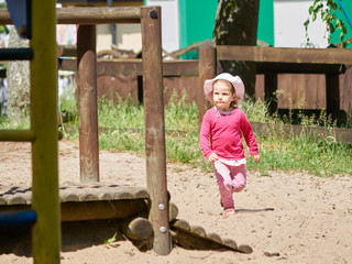 Dziewczynka biega po placu zabaw.