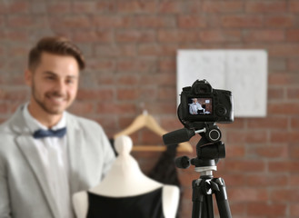 Young fashion blogger recording video at home