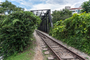 View along the railway. Old railroad across the bridge. The road for the train on the sides of the green vegetation and forest - 179161378