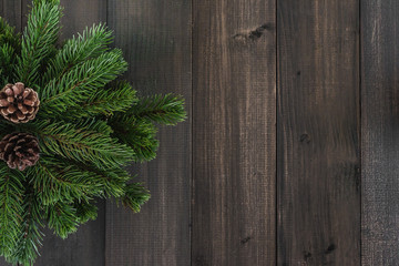 Christmas fir tree branches and pine on dark rustic wooden background with copy space for text