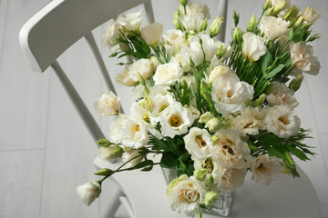 Vase with beautiful eustoma flowers on chair