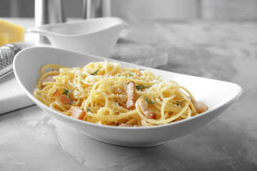 Plate of pasta carbonara with bacon on table