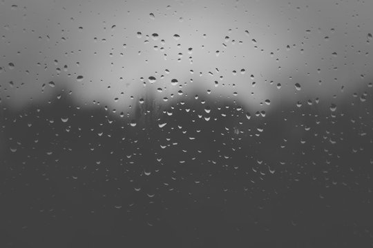 Rain on a glass. Drops of water on the glass. Night rain. Black and white photo