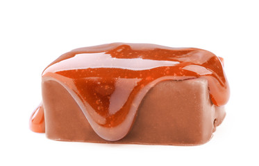 Sweet chocolate candy with caramel topping on white background