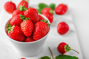 Bowl with fresh strawberries on table, closeup