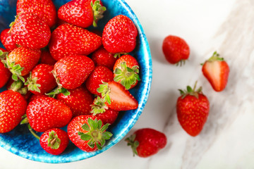 Bowl with fresh strawberries on table