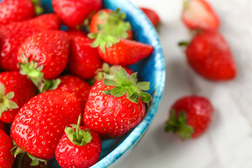Bowl with fresh strawberries on table, closeup
