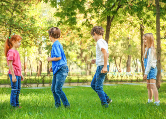 Cute little children jumping rope in park