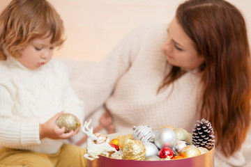 Obraz na płótnie Canvas Mother and child decorating home for Christmas.