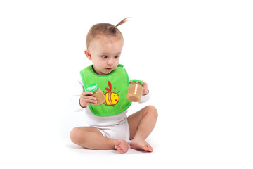 cute beauty little girl in green bib hold baby food