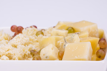Set of cheeses and grapes on a white background