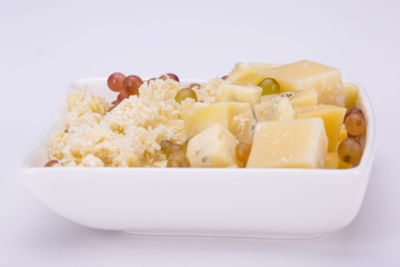 Set of cheeses and grapes on a white background