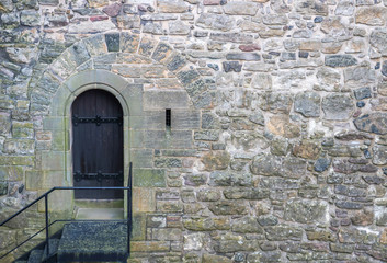 Lone Arched Door in the Stones of a Castle Wall