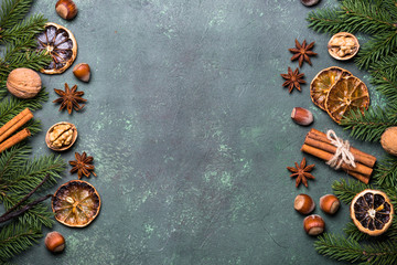 Christmas spices and  decorations on green stone table. Top view copy space.