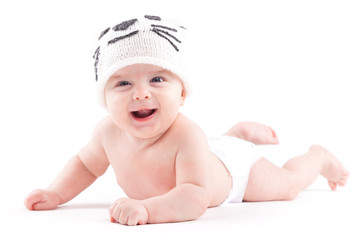 cute pretty baby boy in diaper and cat hat lies on tummy