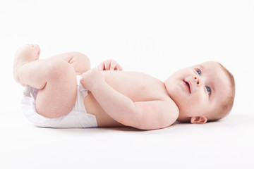cute baby boy in diaper lies on back